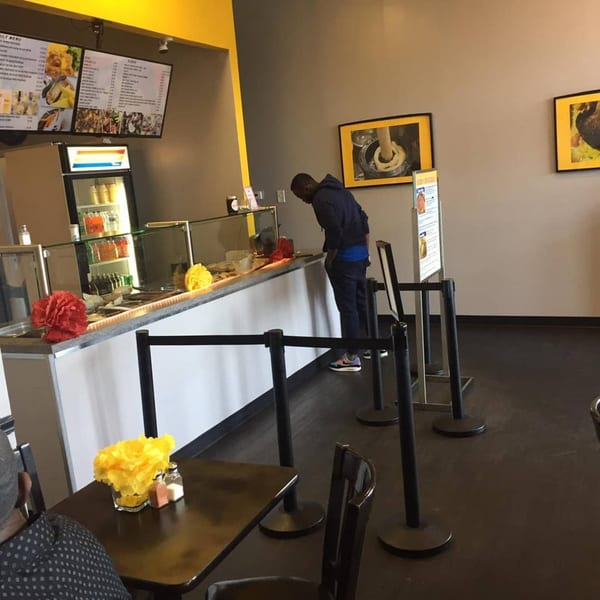 A man orders food at the counter of The Hunger Tamer, an African restaurant.